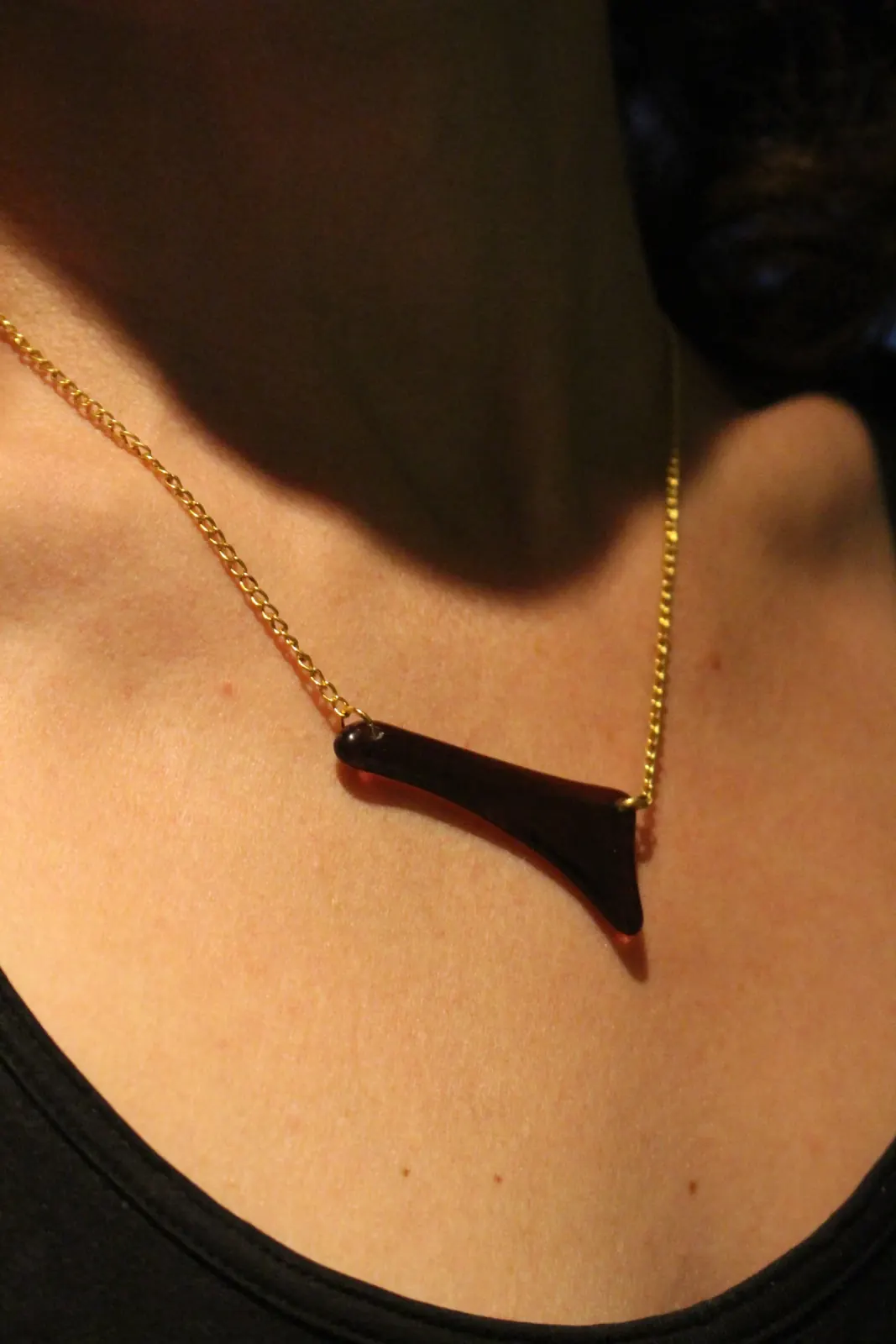 Collier à pendentif asymétrique en verre pourpre et fine chaîne dorée porté au cou