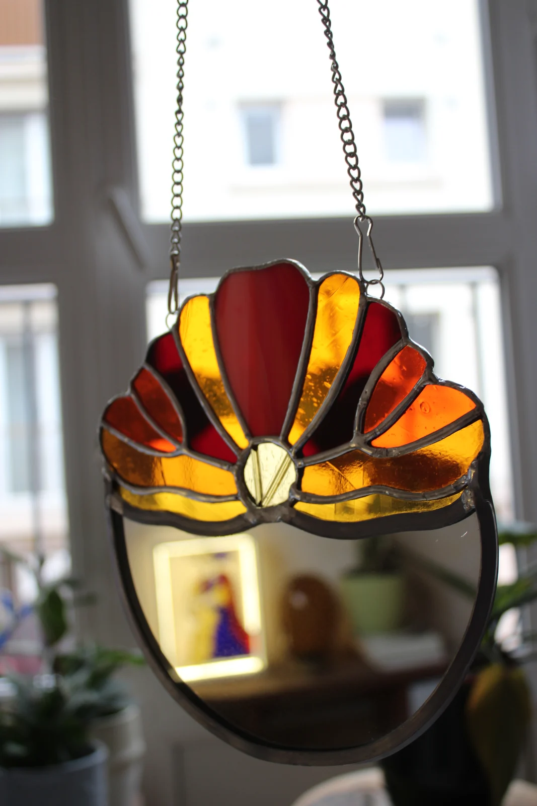 Miroir vitrail Tiffany suspendu en verre orange, rouge et jaune devant une fenêtre