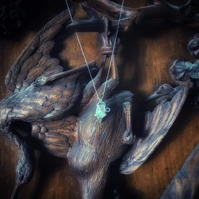 Collier et pendentif opale naturelle avec chaîne en argent 925 suspendu sur un décor en bois.