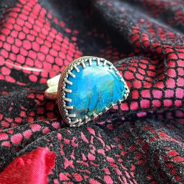 Bague en argent ornée d'une pierre chrysocolle bleue portée à la main