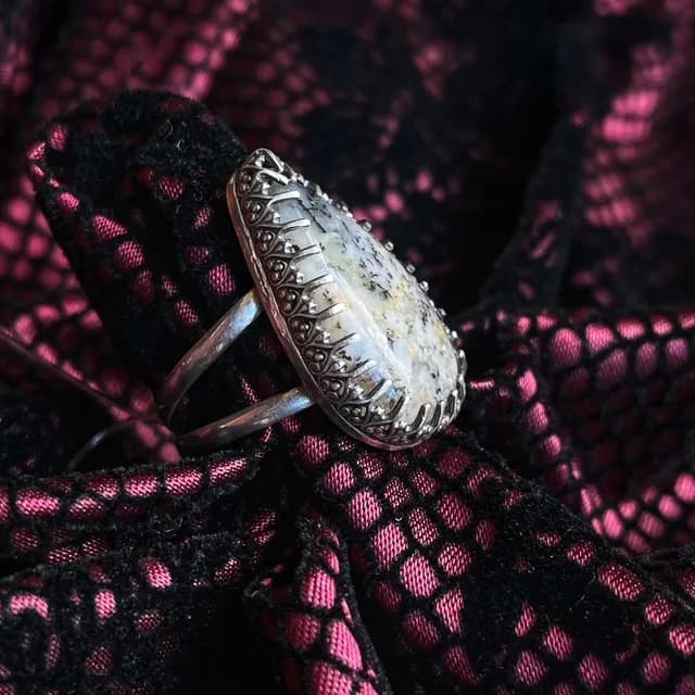 Vue de profil de la bague en argent montrant les détails du sertissage travaillé autour de la pierre.